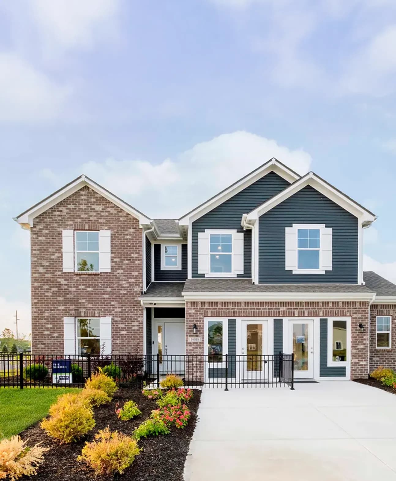 Two story site built home exterior by Arbor Homes by Clayton with brick and blue siding.