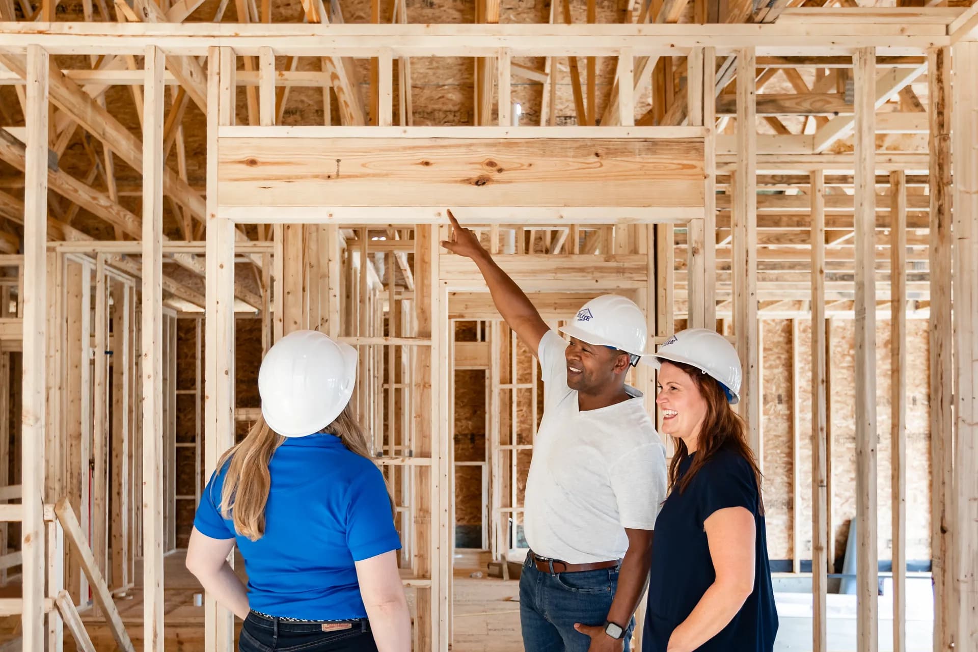 A Clayton Homes builder points to an interior joist as he inspects the new construction site-built property under construction.
