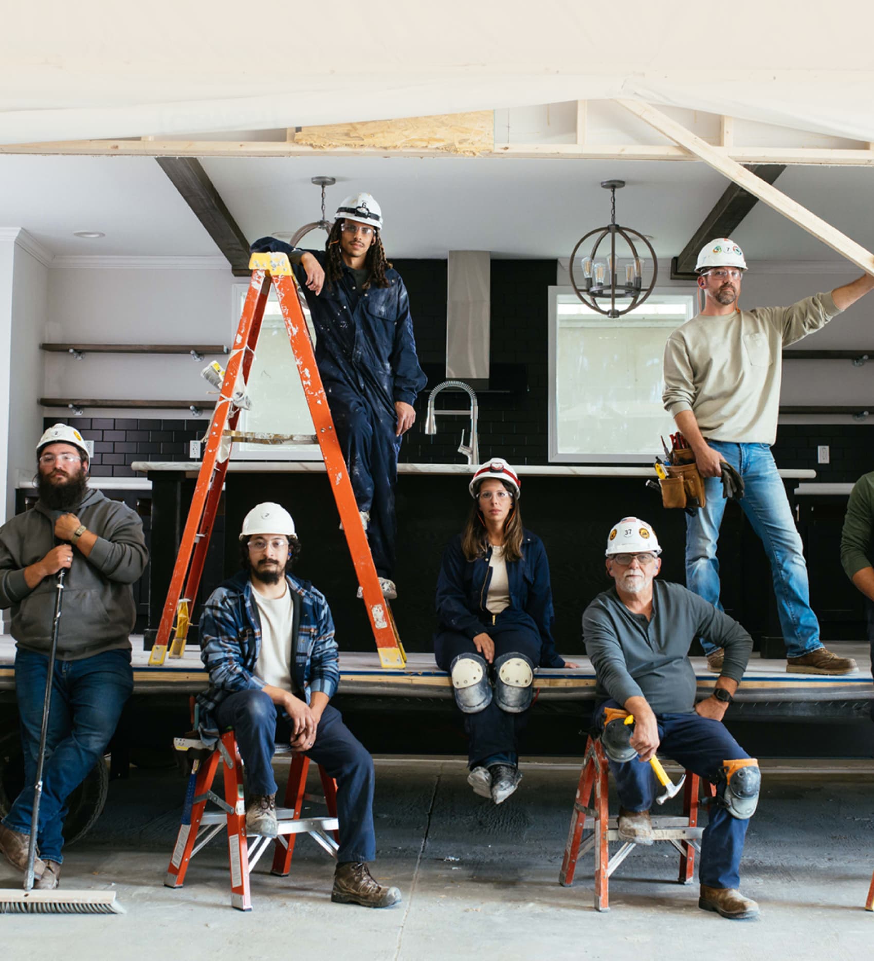 Clayton builders stand together beside a modern manufactured home under construction at a building facility.