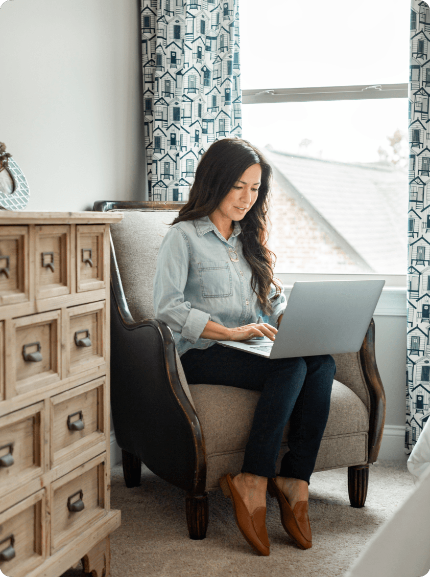 A woman looks at her laptop as she completes the steps of homeownership online.