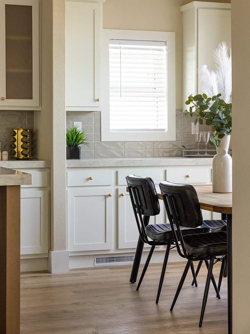 A beautiful interior dining room with a large table, additional built-in cabinet storage, and soft cream color tones.