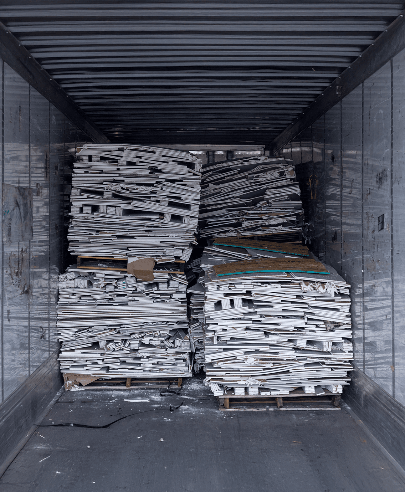 A truck has recycled materials from building new homes, stacked up for processing.