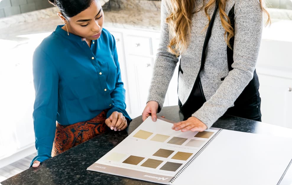 A homebuyer looks at interior material options with a home consultant to personalize her new construction home.