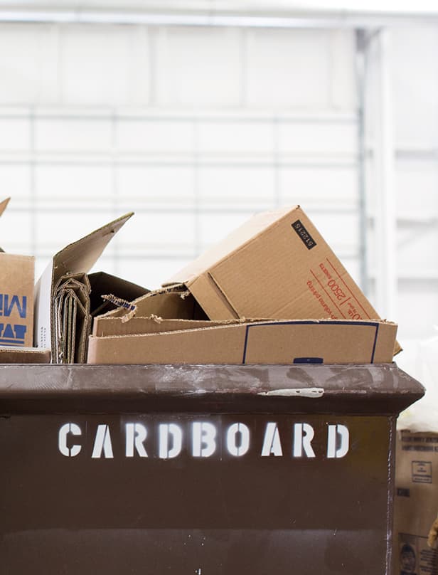 Cardboard boxes are in a recycling bin to be processed as waste is reduced in building facilities.